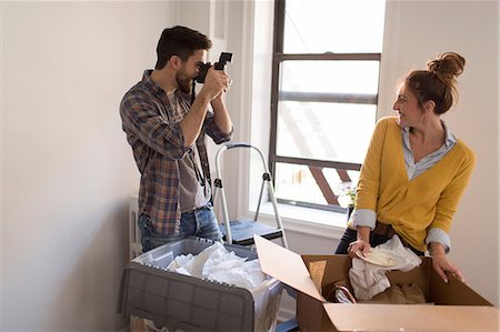 step ladder - Moving house: Young couple unpacking, young man photographing young woman Stock Photo - Premium Royalty-Free, Code: 614-08641555