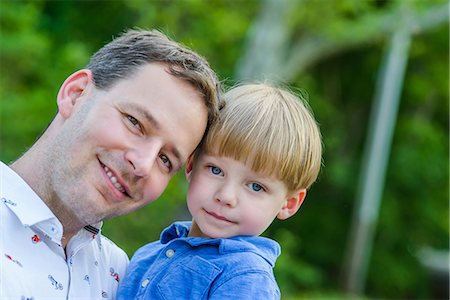 simsearch:632-03848361,k - Father holding son looking at camera smiling Stock Photo - Premium Royalty-Free, Code: 614-08685018