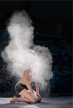 person action - Woman kneeling throwing powder covered hair back Stock Photo - Premium Royalty-Free, Code: 614-08685099