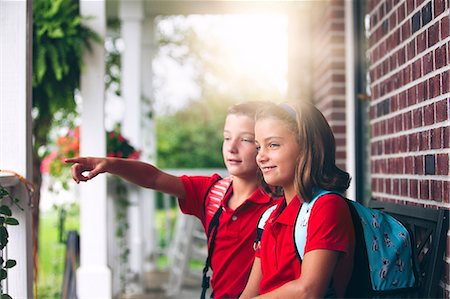 excited kids on first day of school - Twin brother and sister sitting on bench pointing, on first day of new school year Stock Photo - Premium Royalty-Free, Code: 614-08726631