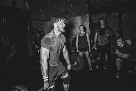 simsearch:693-08126938,k - Cross training athletes observing man lifting barbell in gym Stock Photo - Premium Royalty-Free, Code: 614-08726683