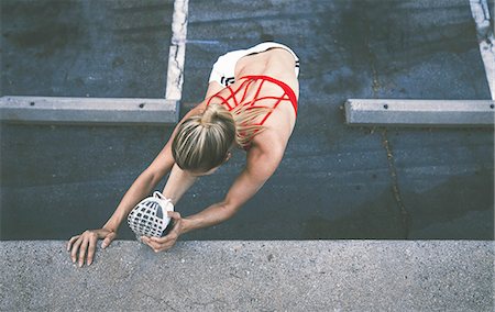 Young woman stretching against wall outdoors Stock Photo - Premium Royalty-Free, Code: 614-08768457