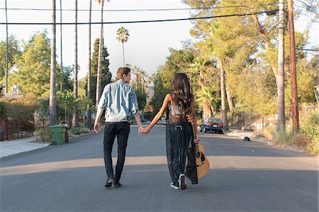 suburb usa california - Young couple walking outdoors, young woman holding guitar, rear view Stock Photo - Premium Royalty-Free, Code: 614-08826915