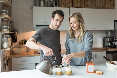 relaxing - Mid adult couple making cup of tea in kitchen Stock Photo - Premium Royalty-Free, Code: 614-08827267