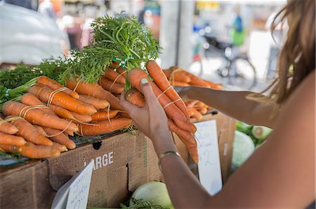simsearch:6108-05874623,k - Woman at fruit and vegetable stall selecting carrots Stock Photo - Premium Royalty-Free, Code: 614-08827325