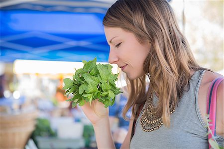 simsearch:6108-05874623,k - Woman at fruit and vegetable stall smelling fresh herbs Stock Photo - Premium Royalty-Free, Code: 614-08827320