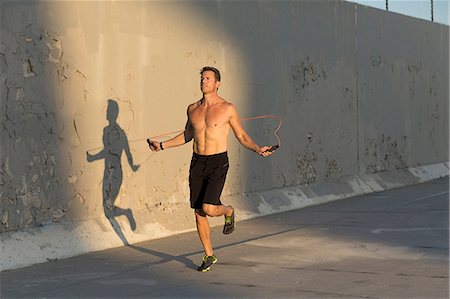 skipping - Male athlete skipping with resistance band Stock Photo - Premium Royalty-Free, Code: 614-08821162