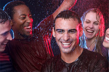 Group of friends dancing in the rain Stock Photo - Premium Royalty-Free, Code: 614-08865798