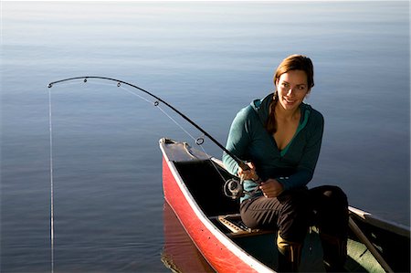 Woman fishing from canoe Stock Photo - Premium Royalty-Free, Code: 614-08865895