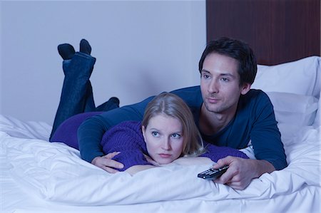 simsearch:400-05686653,k - couple in bed watching TV Stock Photo - Premium Royalty-Free, Code: 614-08866189