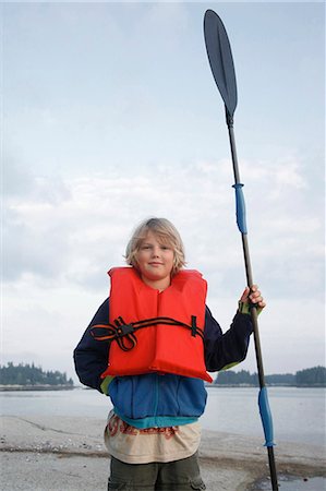 Boy with life vest and kayak paddle Stock Photo - Premium Royalty-Free, Code: 614-08866235