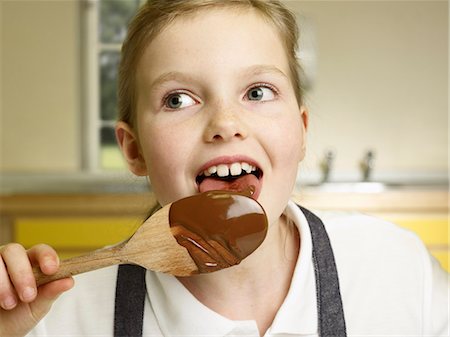 A girl licks a spoon Stock Photo - Premium Royalty-Free, Code: 614-08867377