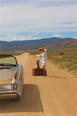 Woman hitching on desert road Photographie de stock - Premium Libres de Droits, Code: 614-08867463