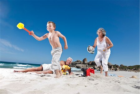 Boy running from grandmother's sunscreen Photographie de stock - Premium Libres de Droits, Code: 614-08867741