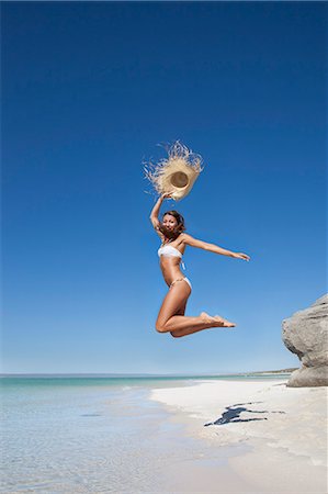 simsearch:649-05819761,k - Woman jumping with straw hat on beach Stock Photo - Premium Royalty-Free, Code: 614-08867883
