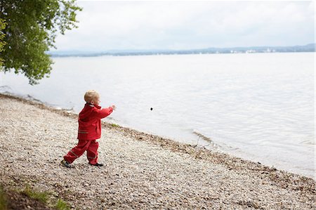 Boy tossing rocks into lake Stock Photo - Premium Royalty-Free, Code: 614-08867921