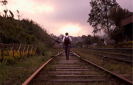 railway - Man backpacking on train tracks Stock Photo - Premium Royalty-Free, Code: 614-08868632