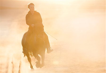 dusty environment - Silhouette of man riding horse in field Stock Photo - Premium Royalty-Free, Code: 614-08869013