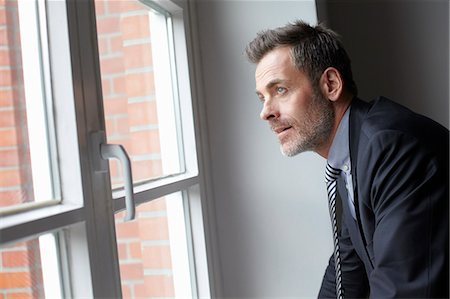 simsearch:649-07119200,k - Businessman looking out window Stock Photo - Premium Royalty-Free, Code: 614-08869053