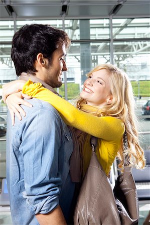 simsearch:649-05556309,k - Couple hugging in airport Stock Photo - Premium Royalty-Free, Code: 614-08869424