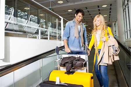 pushing bag - Couple on moving walkway in airport Stock Photo - Premium Royalty-Free, Code: 614-08869425