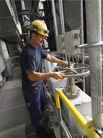 Worker operating machinery in factory Photographie de stock - Premium Libres de Droits, Code: 614-08869597