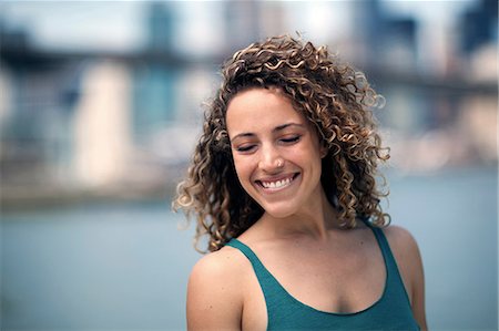 simsearch:400-04435419,k - Portrait of woman with curly hair, smiling Stock Photo - Premium Royalty-Free, Code: 614-08874121