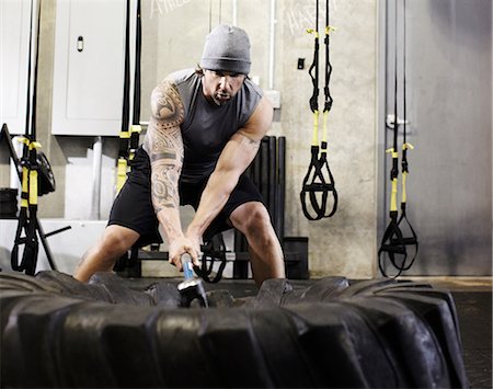 simsearch:693-08126938,k - Man hitting tyre with sledgehammer in a gym Stock Photo - Premium Royalty-Free, Code: 614-08874258