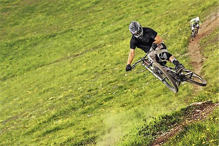 simsearch:6115-06778762,k - Mountain bikers riding down steep grassy slope Photographie de stock - Premium Libres de Droits, Code: 614-08874977