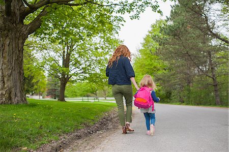 simsearch:695-03386286,k - Rear view of mother and daughter holding hands walking down road through woods Stock Photo - Premium Royalty-Free, Code: 614-08875420