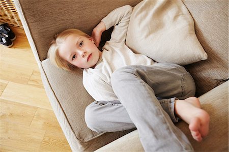 Young girl lying in armchair, portrait Stock Photo - Premium Royalty-Free, Code: 614-08875647