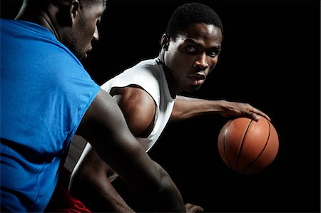 person action - Male basketball players competing for ball Stock Photo - Premium Royalty-Free, Code: 614-08875661