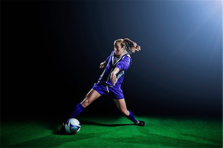 female playing soccer - Young female soccer player dribbling ball Stock Photo - Premium Royalty-Free, Code: 614-08875686