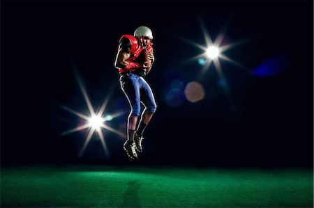simsearch:649-07239531,k - American football player mid air with ball Stock Photo - Premium Royalty-Free, Code: 614-08875722