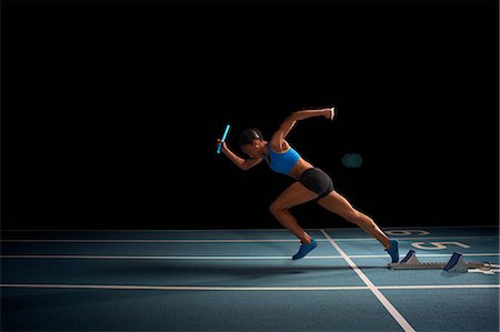 running track night - Young female athlete in relay race Stock Photo - Premium Royalty-Free, Code: 614-08875903