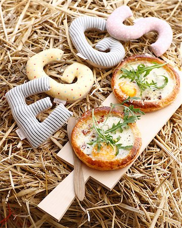 Still life of fresh pancetta tarts with rocket garnish Photographie de stock - Premium Libres de Droits, Code: 614-08875990