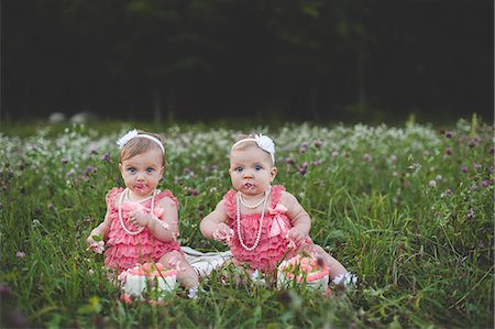 surprised kids - Portrait of baby twin sisters sitting in wildflower meadow eating birthday cake Stock Photo - Premium Royalty-Free, Code: 614-08877017