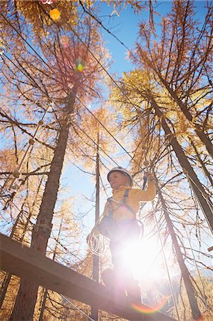 simsearch:614-07031875,k - Young boy climbing in forest, attached to high line rope, low angle view Foto de stock - Sin royalties Premium, Código: 614-08877189