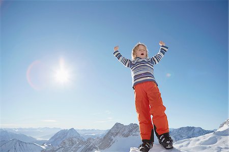 simsearch:614-06896861,k - Young boy standing in snowy landscape, celebrating with arms raised, low angle view Stock Photo - Premium Royalty-Free, Code: 614-08877225