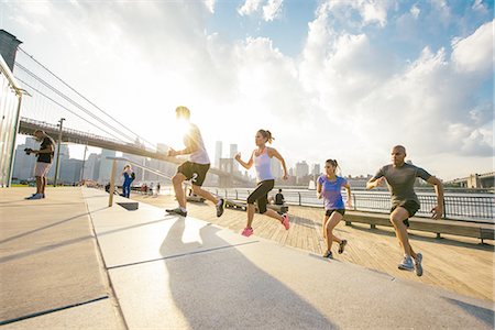 Four running friends running up riverside stairs, New York, USA Stock Photo - Premium Royalty-Free, Code: 614-08878661