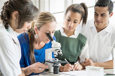simsearch:614-06973669,k - Students watching teacher use microscope in lab Stock Photo - Premium Royalty-Free, Code: 614-08878770