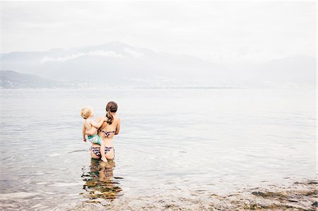 simsearch:614-05557077,k - Rear view of mother standing in lake holding boy looking away at view of mountain range, Luino, Lombardy, Italy Stock Photo - Premium Royalty-Free, Code: 614-08879291