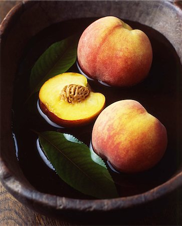 simsearch:614-01088098,k - Whole and half peaches and leaves in vintage wooden bowl of water Stock Photo - Premium Royalty-Free, Code: 614-08879310