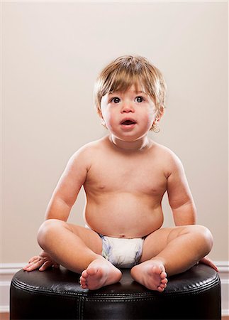 Toddler boy sitting on ottoman Stock Photo - Premium Royalty-Free, Code: 614-08870702