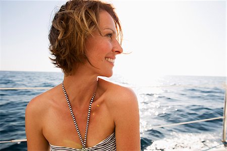 Smiling woman in bikini on boat Stock Photo - Premium Royalty-Free, Code: 614-08870968