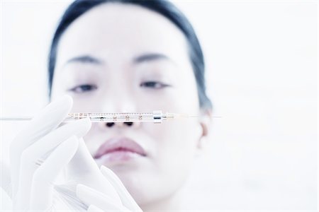 simsearch:614-06813654,k - Woman examining syringe Foto de stock - Sin royalties Premium, Código: 614-08871386