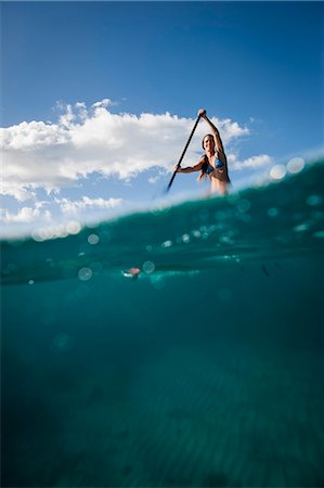 Woman paddleboarding on ocean Stock Photo - Premium Royalty-Free, Code: 614-08871423