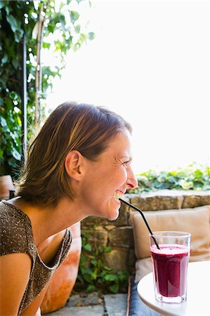Woman drinking drink with straw Stock Photo - Premium Royalty-Free, Code: 614-08871558