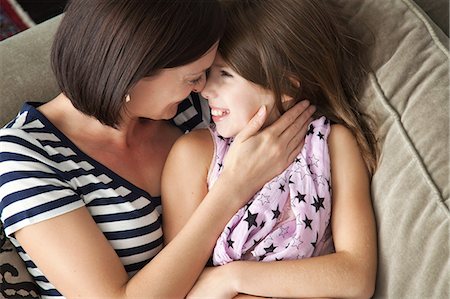 simsearch:614-06442812,k - Mid adult woman hugging daughter on sofa Stock Photo - Premium Royalty-Free, Code: 614-08873036