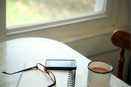 Table with coffee cup and spectacles Stock Photo - Premium Royalty-Free, Code: 614-08873329